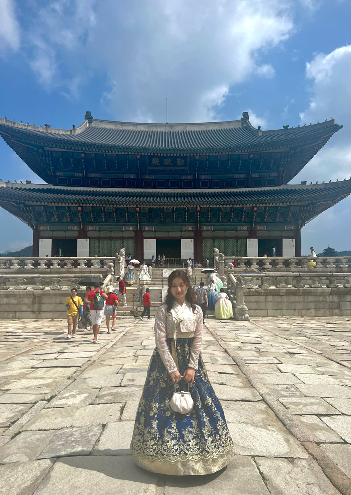 Photo of Sohee Kim wearing hanbok in front of Gyeongbokgung Palace
