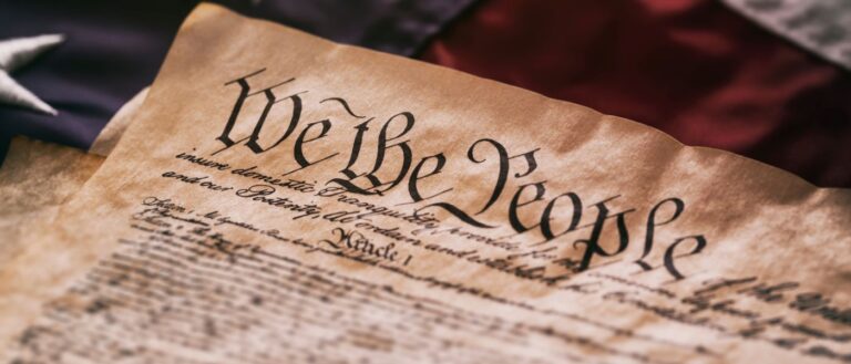 Close up of the U.S. constitution with an American flag background