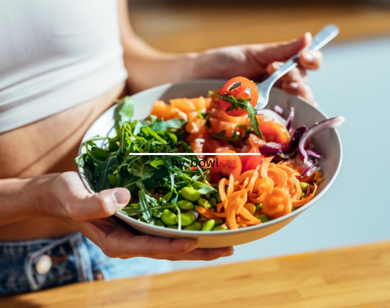 Shot of fitness woman eating a healthy poke bowl in the kitchen at home.