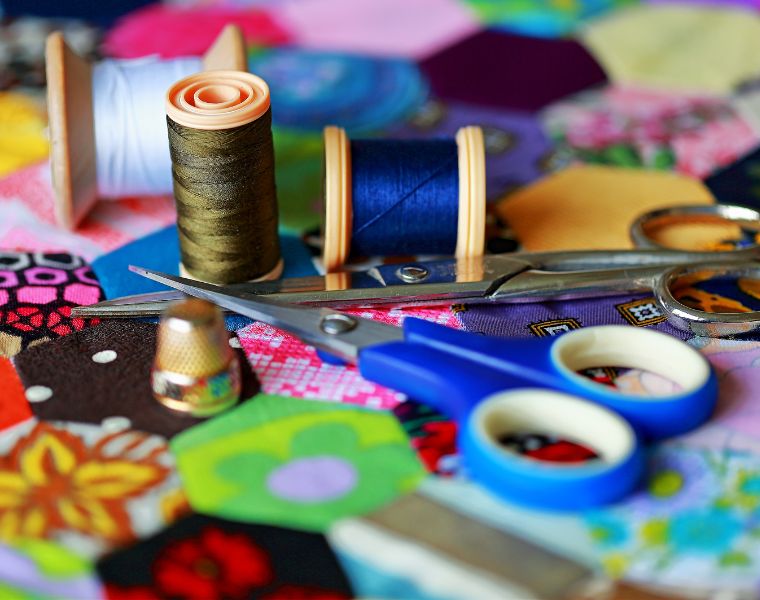 Cotton reels,thimble and scissors on a homemade patchwork quilt