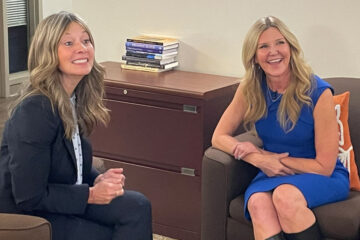 Photo of Amy Acton and Eileen Anderson sitting together and smiling for a photo during an interview