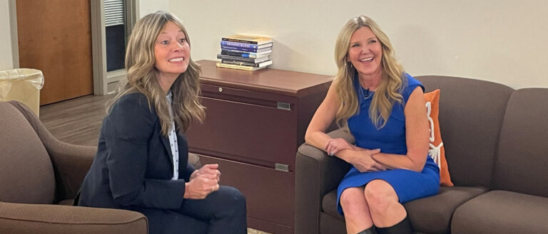 Photo of Amy Acton and Eileen Anderson sitting together and smiling for a photo during an interview
