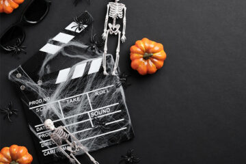 Stock image of pumpkins and a skeleton with a movie marker covered in cobwebs