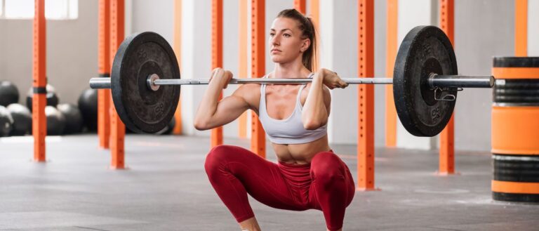 Photo of a muscular weightlifter doing barbell front squat