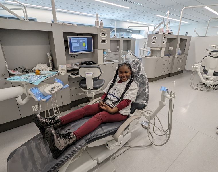 Photo of a child smiling in dentist chair during the Give Kids a Smile event