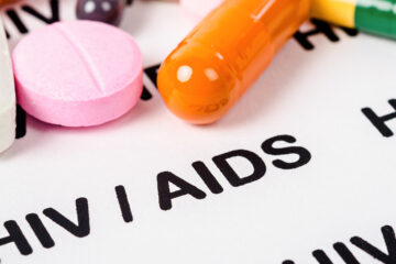 Stock image of colorful medication on a printed page reading "HIV/AIDS"