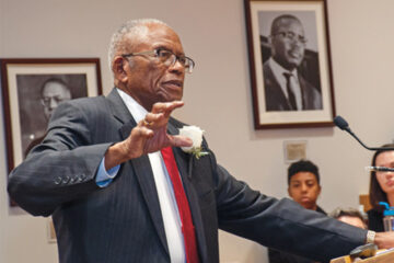 Civil Rights Movement leader Fred Gray stands at a podium before an audience