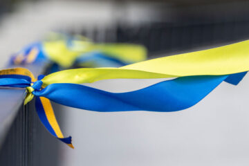 Photo of blue and yellow ribbons tied to a railing