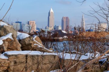 Views of Clevelands skyline beyound boulders and shrubs along the wintery shoreline of Lake Erie at Edgewater Park in Cleveland, Ohio. Courtesy of Getty Images.