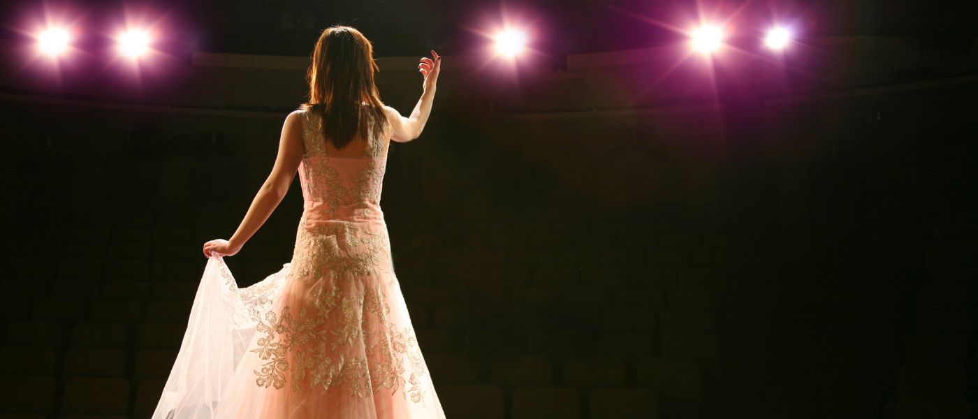 Back view of an opera singer on stage. Courtesy of Getty Images.