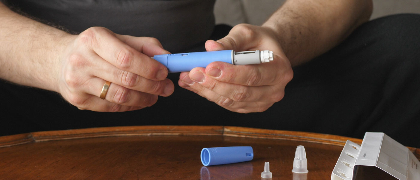 Photo of a person preparing Semaglutide Ozempic injection pen to control blood sugar levels