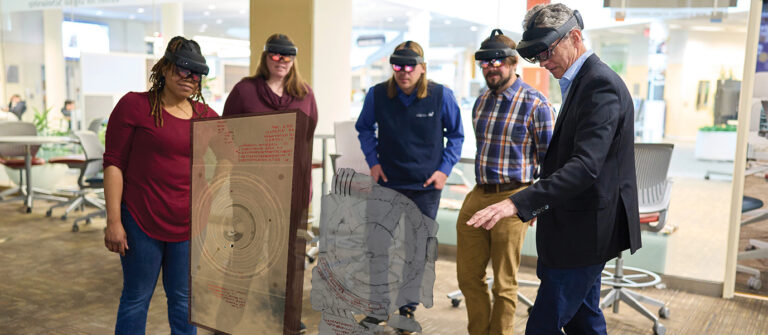 Associate Professor Paul Iversen showing HoloLens images of the Antikythera mechanism to staff members of the Cleveland Museum of Natural History. |