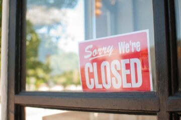 Photo of a sign in a storefront window that reads "Sorry, We're Closed". Courtesy of Getty Images