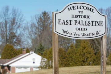 Photo of the East Palestine welcome sign with residential houses in the background