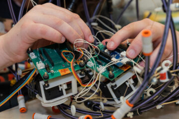 Close up photo of someone's hands working on a robotics research project in a CWRU lab