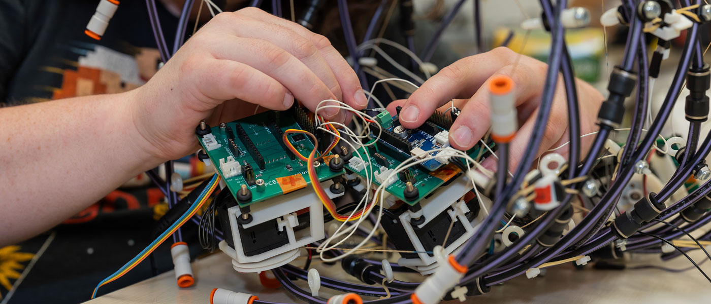 Close up photo of someone's hands working on a robotics research project in a CWRU lab
