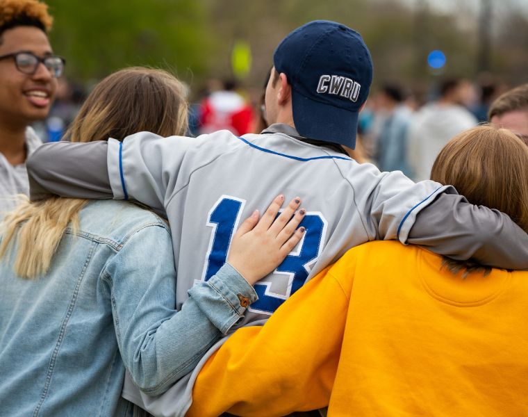 Back view of students laughing and hugging during CWRU Springfest.