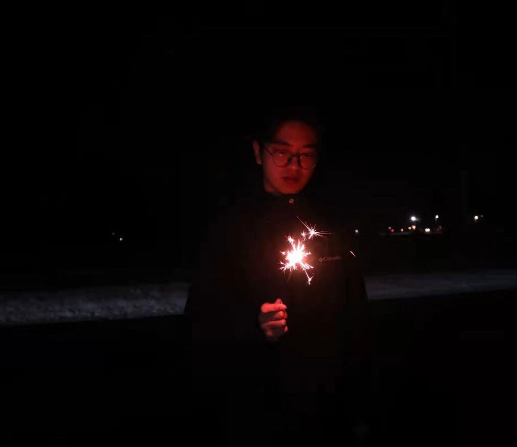 Photo of Zayn Wang holding a sparkler to celebrate the Lunar New Year