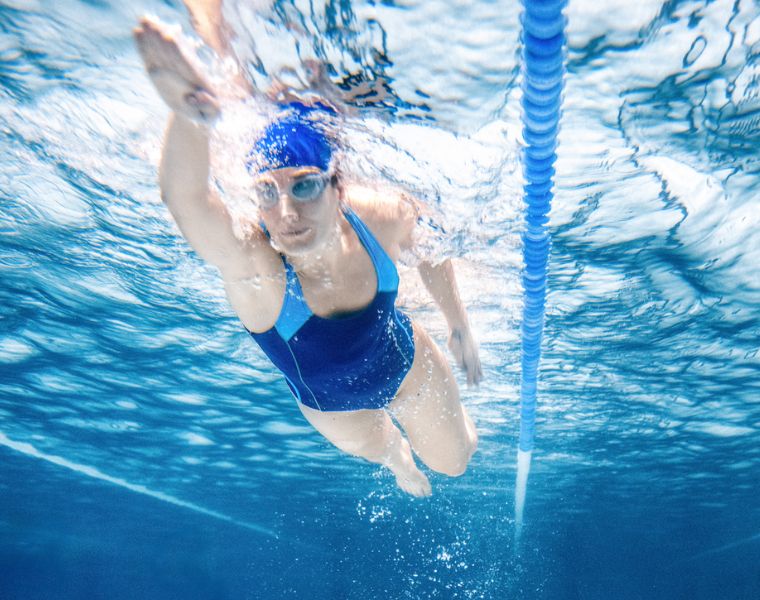 Under water shoot of a woman swimming freestyle in olympic pool