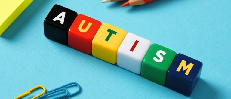 Close up of multicolor blocks that spell "AUTISM"