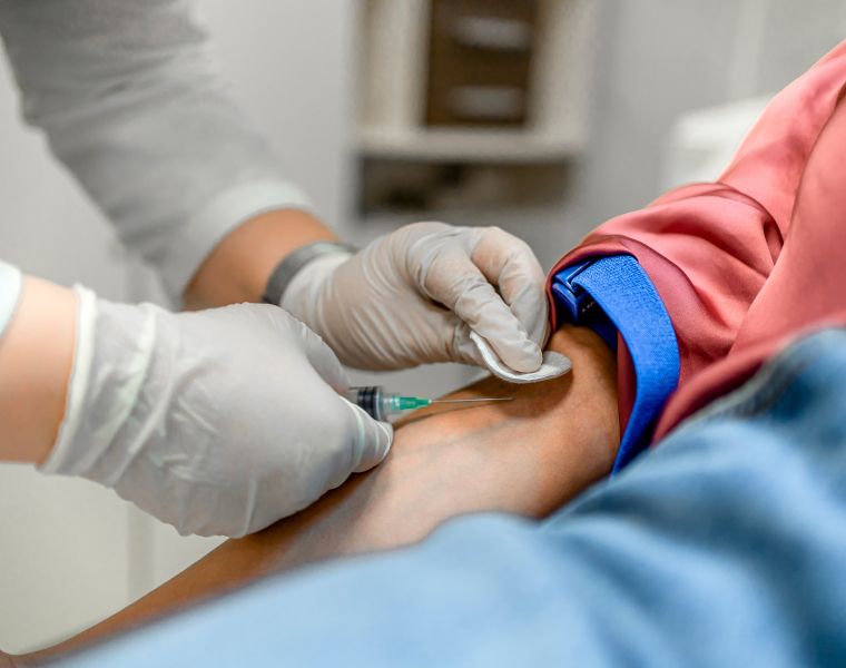 Nurse drawing blood from a female patient's arm vein in the medical clinic. Courtesy of Getty Images.
