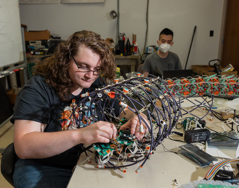 Photo of a researcher working on a worm-like mechanical device