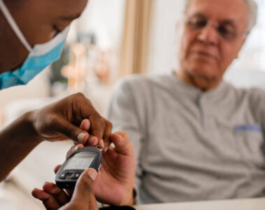 Photo of a healthcare professional checking a patient's glucose levels