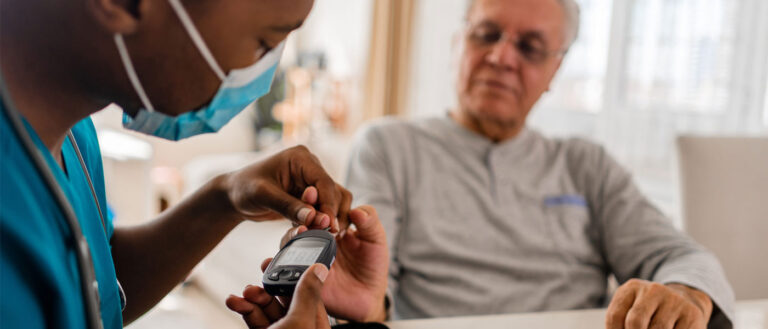 Photo of a healthcare professional checking a patient&#039;s glucose levels