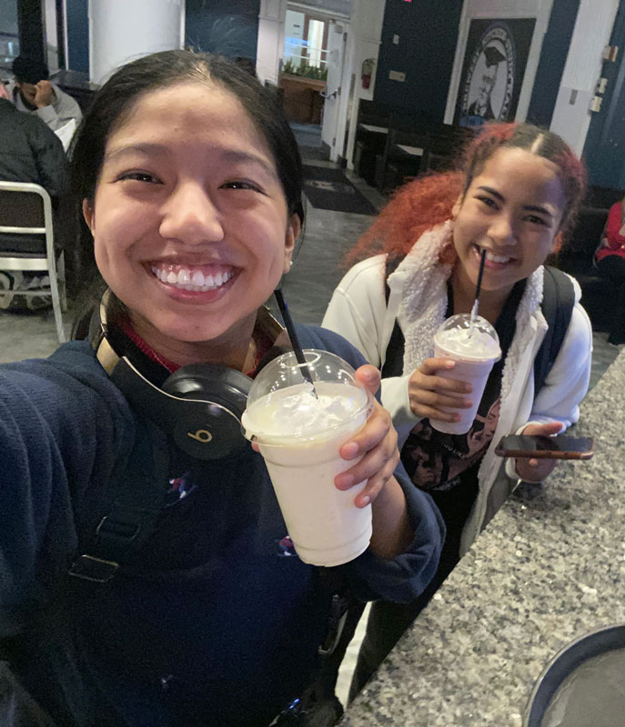Photo of Kelsey Lopez and Lyris Gordon posing for a photo holding milkshakes