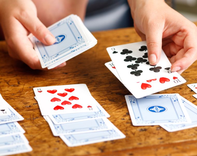 Hands Playing Solitaire Card Game. Courtesy of Getty Images.