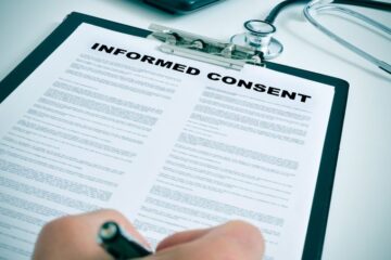 Photo of a patient signing an informed consent form. Courtesy of Getty Images.