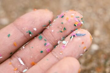 Close up side shot of microplastics lay on people hand. Photography by Getty Images.