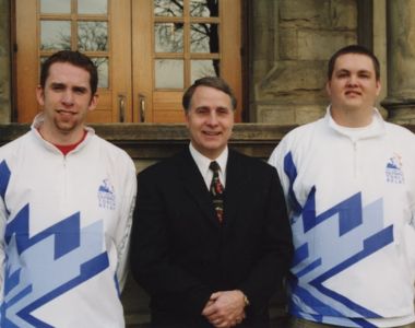 Photo of Jason Bradshaw (far left) with then-University President Jim Wagner and Erik Petersen sporting the jackets they wore to carry the Olympic torch.