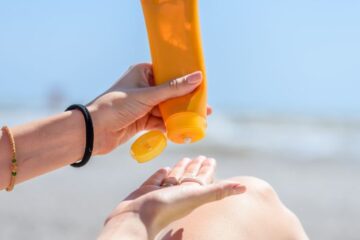 Photo of a woman holding bottles of sunscreen in her hands. Courtesy of Getty Images.