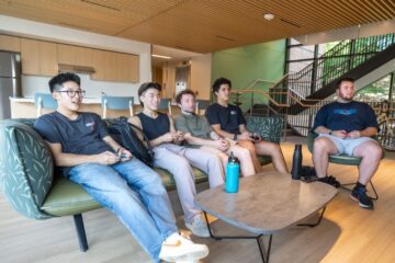 Interior view of new residence hall with a group of students at South Residential Village