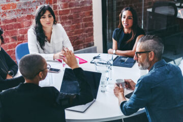 Photo of a group of people around a table in a business meeting