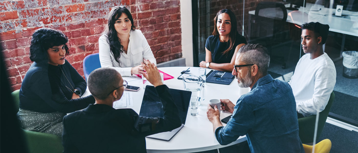 Photo of a group of people around a table in a business meeting