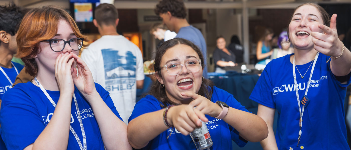 Photo of students singing and dancing while wearing blue CWRU gear