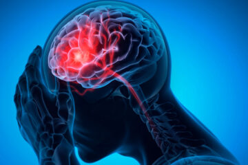 Photo illustration of a human figure with a hand on their head and the brain highlighted in red to signify pain