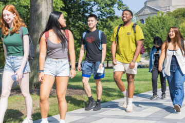 Photo of CWRU students walking and talking on the Binary Walkway at the beginning of the 2024-25 academic year