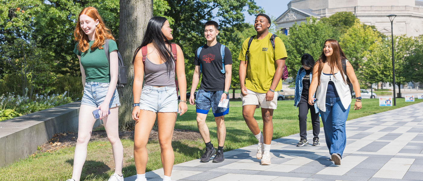 Photo of CWRU students walking and talking on the Binary Walkway at the beginning of the 2024-25 academic year