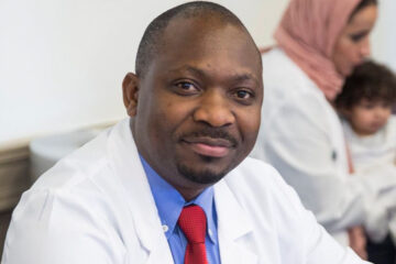 Photo of Fredrick Kizito in a lab coat