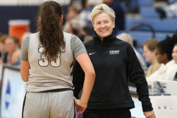 Photo of CWRU women's basketball coach Jennifer Reimer on the sidelines with a player during a game