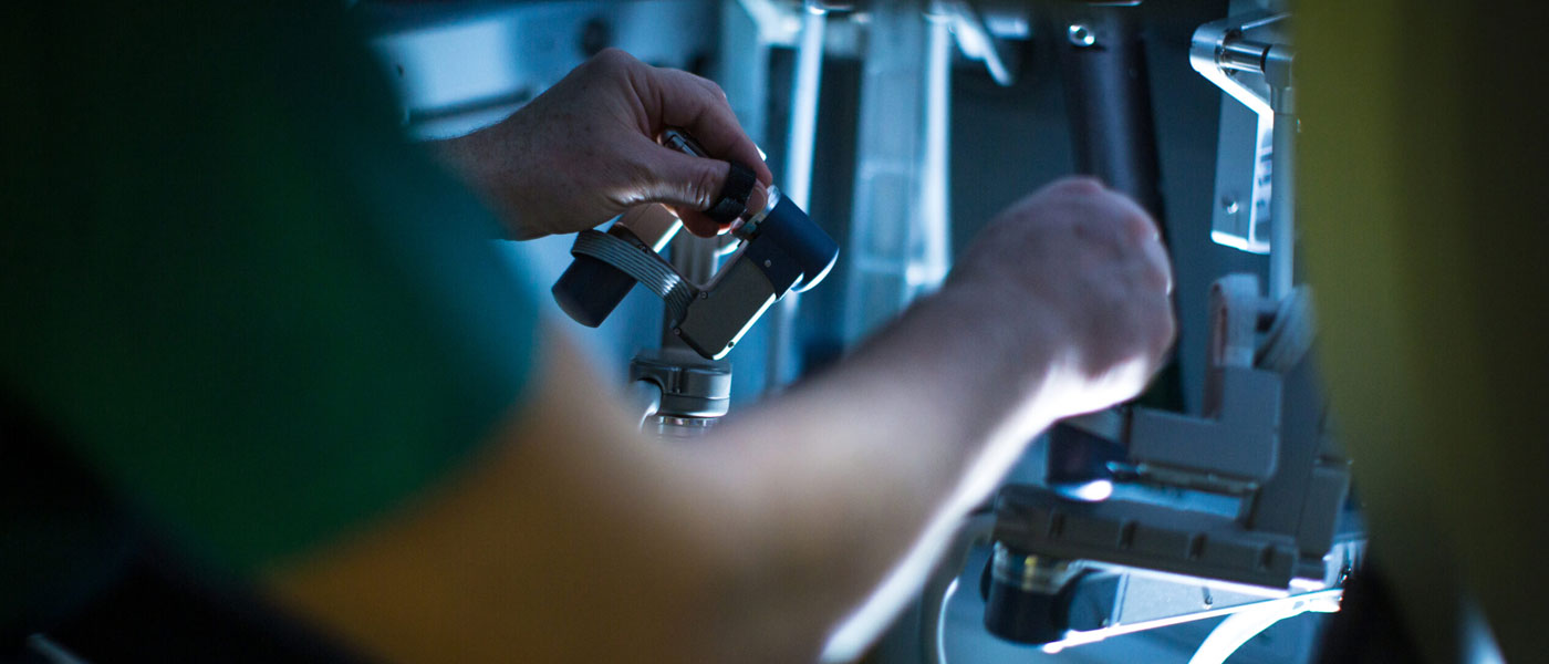 Close up photo showing a surgeon's arms and hands working on precision surgery using a robot