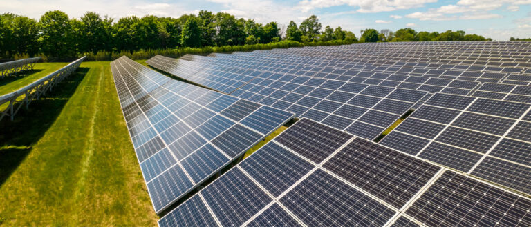 Photo of rows of solar panels on a solar farm