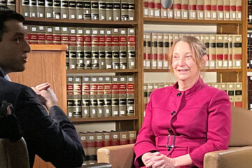 Photo of a faculty member sitting down for an on-camera interview with a journalist