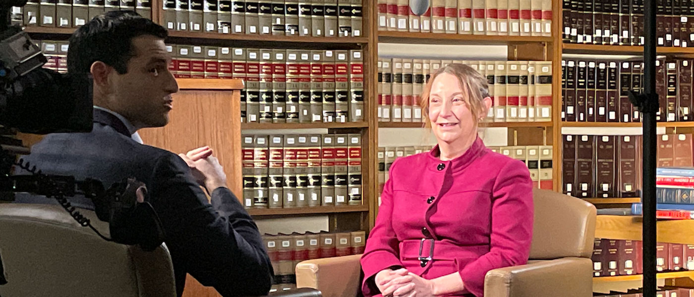 Photo of a faculty member sitting down for an on-camera interview with a journalist