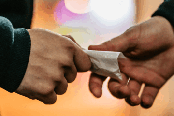 close-up of a hand-to-hand drug deal