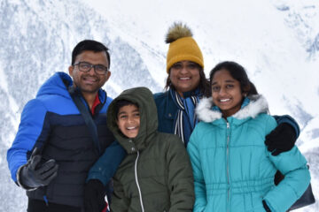 Photo of a younger Nivedita Srinivasan with her family on a snowy holiday vacation