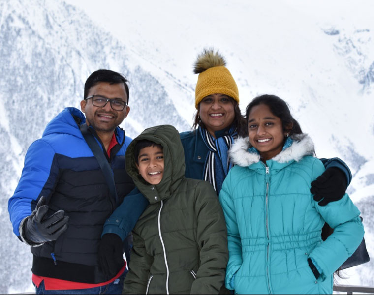 Photo of a younger Nivedita Srinivasan with her family on a snowy holiday vacation